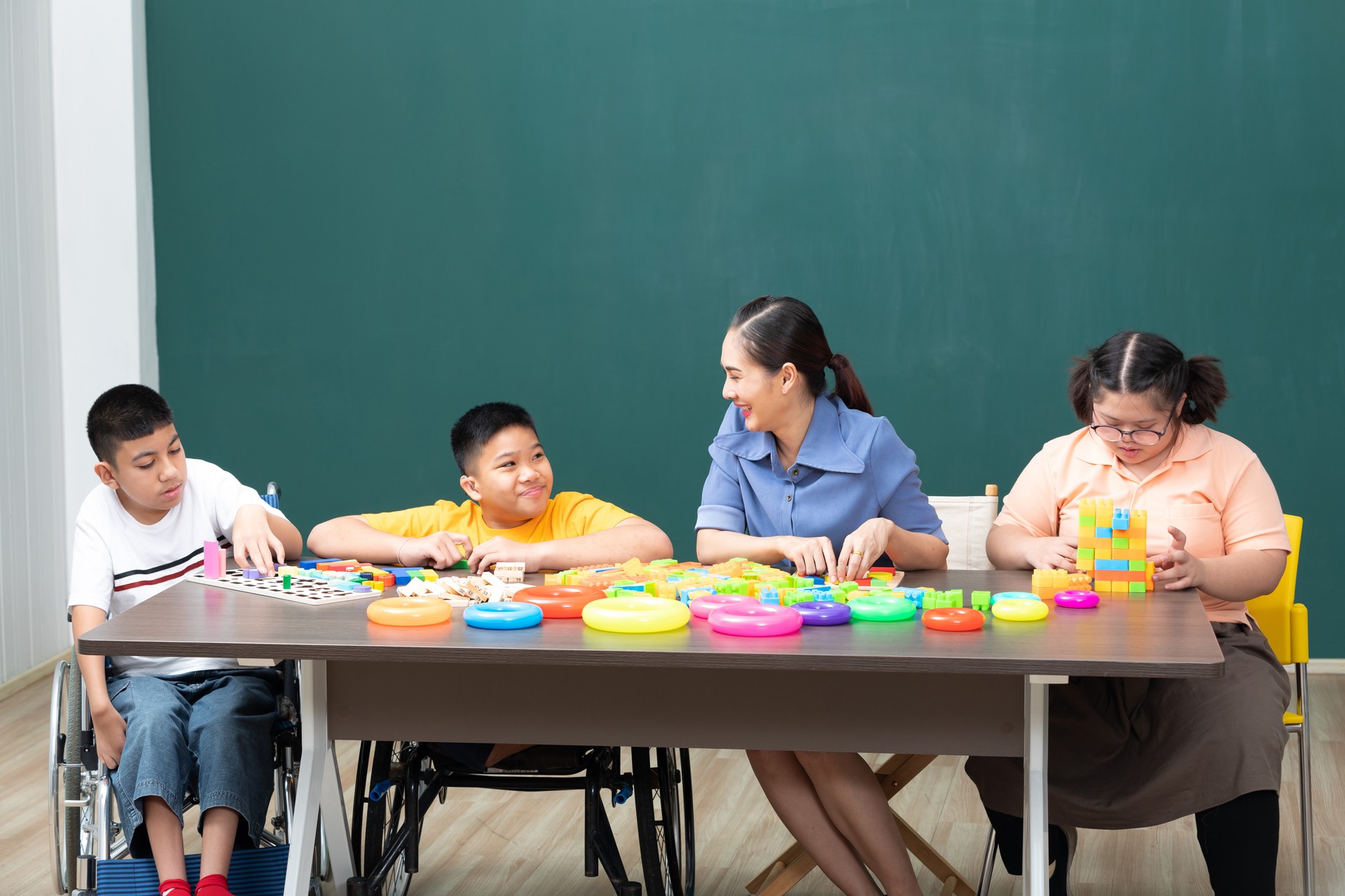 asian disabled kids or autism child playing toys with teacher helping in classroom